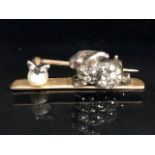 Yellow metal bar brooch mounted with a white metal diamond set rabbit staring at a pearl apple