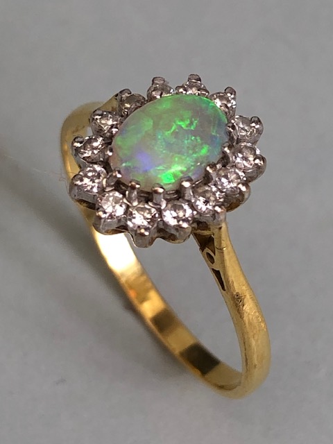 18ct Gold ring set with an oval Opal and surrounded by diamonds 'P'
