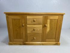 Modern light wood oak effect sideboard with three central drawers flanked by two cupboards, approx