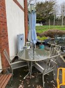 Circular glass topped garden table with four chairs and parasol