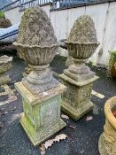 Two decorative concrete garden acorns on square plinth bases, approx 102cm tall