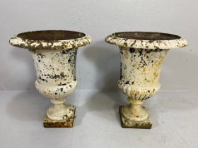 Pair of wrought iron painted and weathered urns, on square plinth base, of classic shape and form,