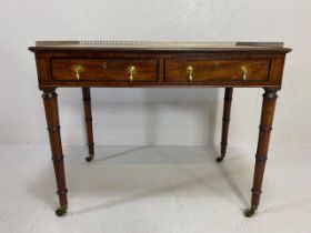 Leather topped writing desk on turned legs with castors, two drawers and metalwork gallery, and