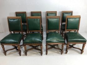 Set of eight Victorian green leather upholstered dining chairs, on cared and turned legs, each