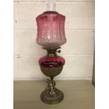 Antique Victorian cranberry glass oil lamp with brass cherub base approximately 57cm high