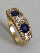 A sapphire and diamond boat shaped ring, with three Diamonds and two faceted Sapphire stones (A/