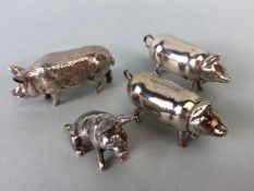 A pair of silver (925) vesta pigs with sprung loaded heads, a seated Hallmarked 925 pig and one