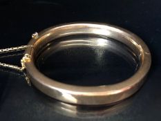 Unmarked Gold bangle approx 65mm across with safety chain total weight approx 18.5g