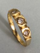 Unmarked yellow gold ring set with tree inset diamonds in square gold raised panels approx size '