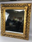 Vintage bevelled glass mirror set in a thick Rococo style gilt wooden frame approximately 62cm x