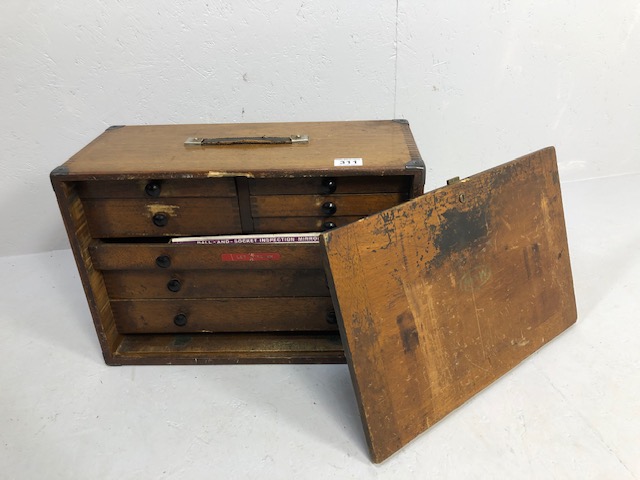 Wooden portable tool chest opening to reveal nine drawers and containing various engineering tools