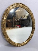 Vintage mirror oval glass wall mirror set in a gilt frame of pierced scroll leaf pattern