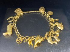 9Ct Gold charm bracelet with a collection of 9ct gold charms, to include, rabbit, Dolphins, Boot,