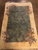 Chinese wool rug of sculpted style with typical designs of flowers against a blue grey back ground