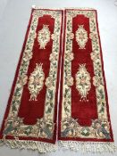 Chinese wool rugs, two sculpted hall runners with typical designs of flowers against red back ground