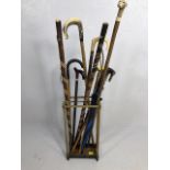 Collection of vintage walking sticks and hiking poles in a Victorian style brass stand 10 items