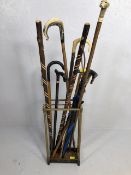 Collection of vintage walking sticks and hiking poles in a Victorian style brass stand 10 items