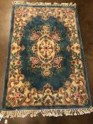 Chinese wool rug of sculpted style with typical designs of flowers and against a blue grey back