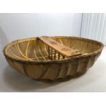 Coracle boat made by Flaxland using wood, woven flax and natural resins, the seat carved with