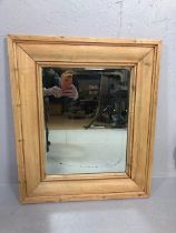 Antique bevel edged mirror in a wide stripped Pine frame approximately 55 x 65cm
