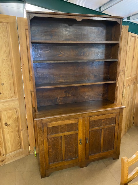 Arts and Crafts oak dresser with shelves above and two cupboards under by maker Curtiss & Sons,