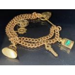 9ct gold twin chain charm bracelet with heart clasp and a selection of 5 charms to include seal fob,