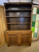 Arts and Crafts oak dresser with shelves above and two cupboards under by maker Curtiss & Sons,