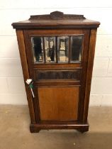 Oak cupboard with bevelled glass inserts and carved panel, opening to three shelves, with original