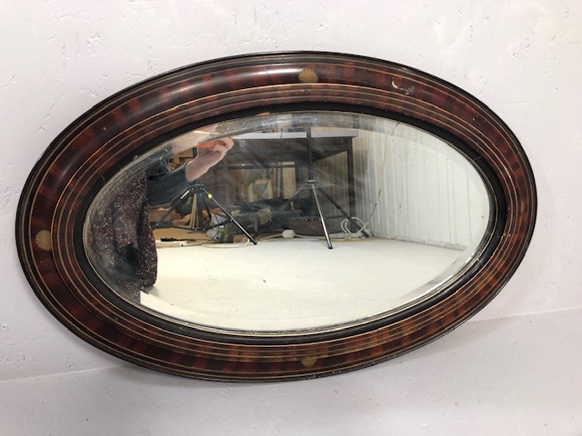 Antique mirror early 19th century oval bevel glass mirror in flame mahogany and ebonised frame