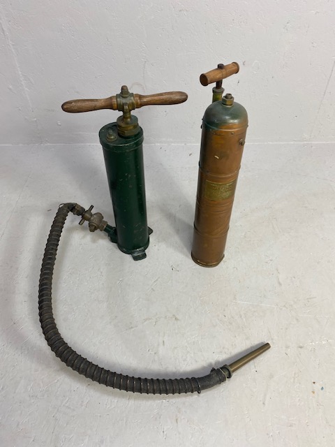 Decorators interest, two antique hand extinguisher pumps, one copper the other metal, with copper