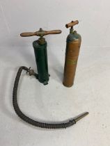 Decorators interest, two antique hand extinguisher pumps, one copper the other metal, with copper