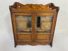 Antique Smokers cabinet, in light oak, part glazed doors opening to show drawers and pipe rack