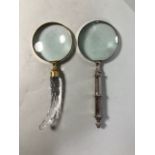 Two desk top magnifying glasses one with glass handle the other with metal handle