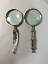 Two desk top magnifying glasses one with glass handle the other with metal handle