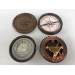Two larger pocket style compasses one of sundial design the other of calendar design