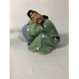 Chinese style figure of a man asleep on a vase approximately 12cm high