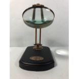 Laboratory style brass framed magnifying glass on wooden base