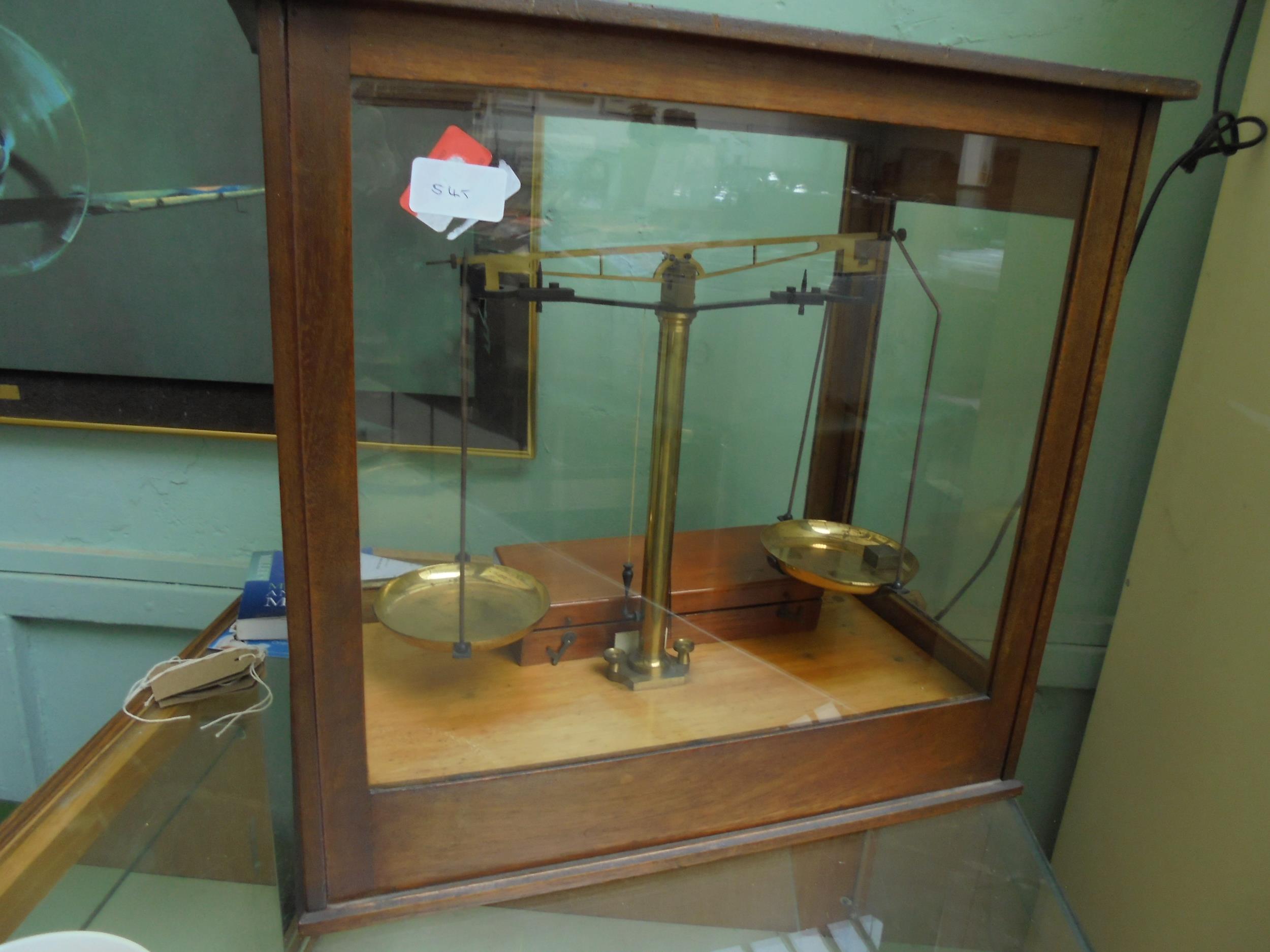 Complete set of weighing scales in 4 sided glass case with box of weights