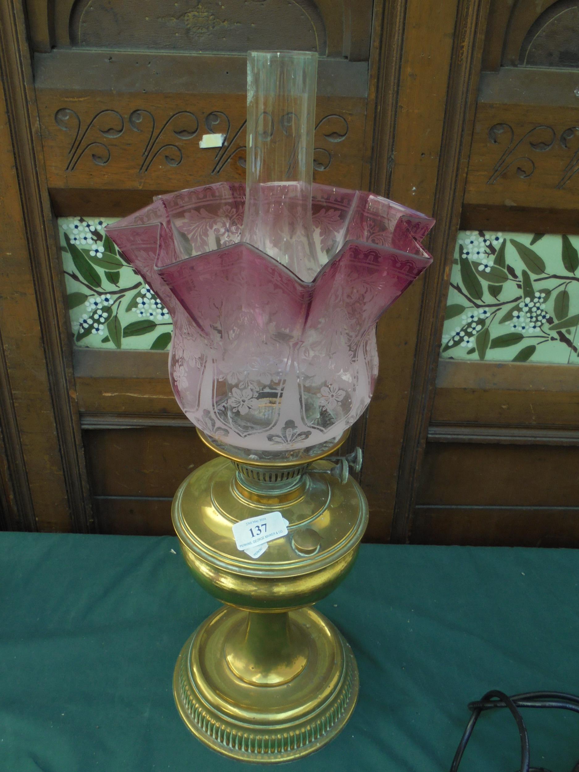 Brass oil lamp with pink decorative shade