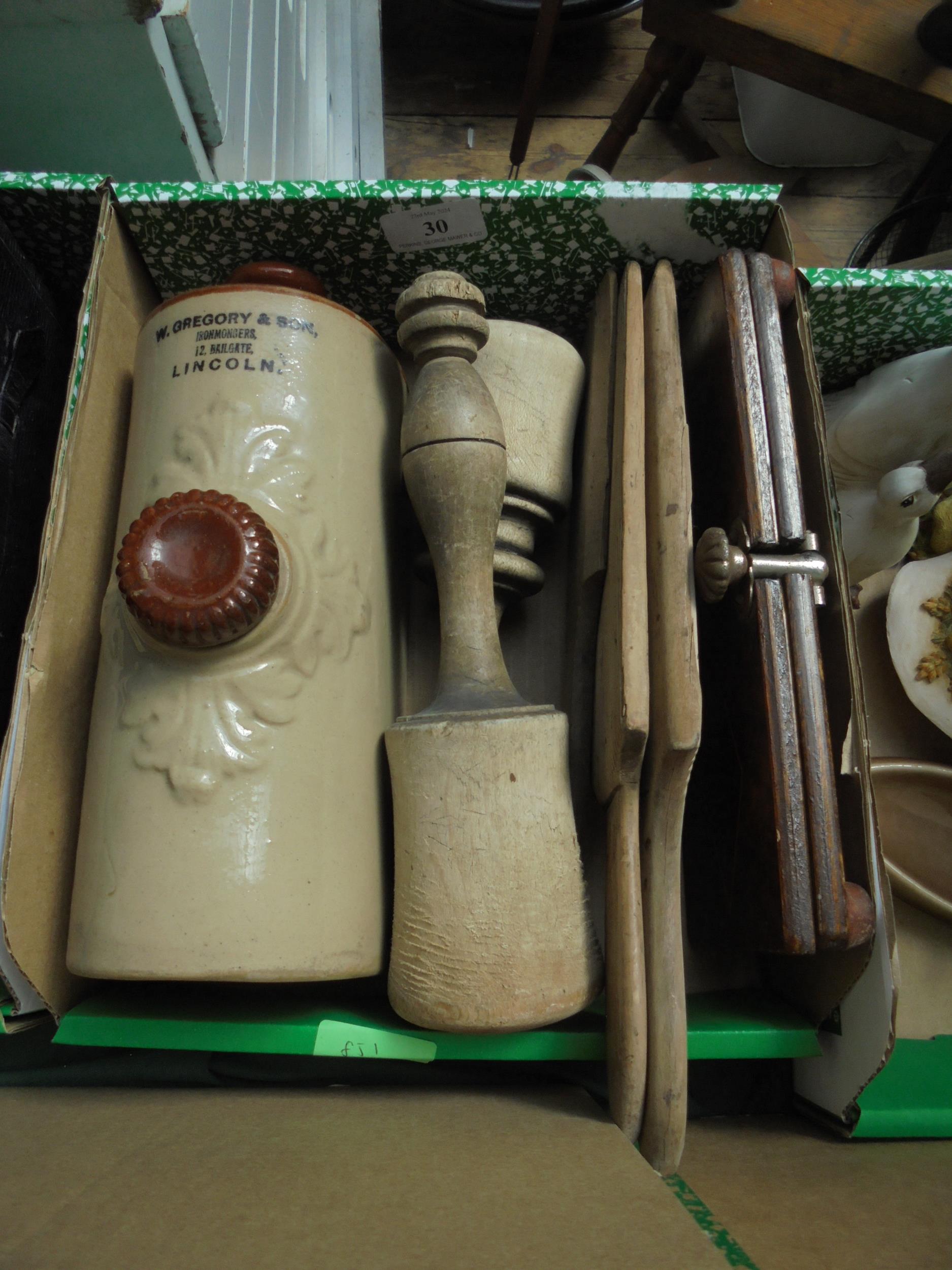 Box of kitchen treen including potato mashers, tie press and hot water bottle marked W.