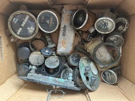 A box of assorted vintage car gauges.