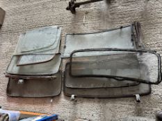 A quantity of early windscreens, side windows, some with fittings and in frames