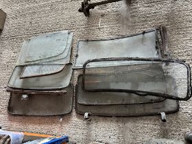 A quantity of early windscreens, side windows, some with fittings and in frames