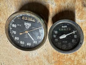 Two Smiths black-faced speedometers.