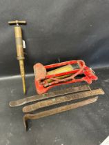 A Kismet foot pump, a brass grease gun and three large tyre levers.