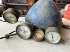 A large headlamp and four pressure gauges.