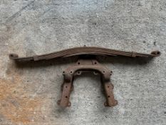 A vintage car leaf spring and bracket.