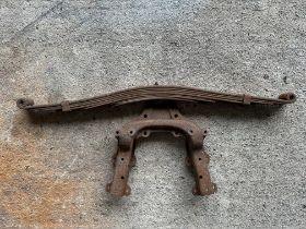 A vintage car leaf spring and bracket.