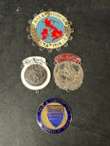 Three enamel supplier dashboard plaques, badges, emblems and a Vespa rally plaque. One for Ford,