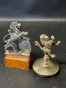 Two car accessory mascots depicting rampant lions, one possibly Gilbert & Son (with shield of